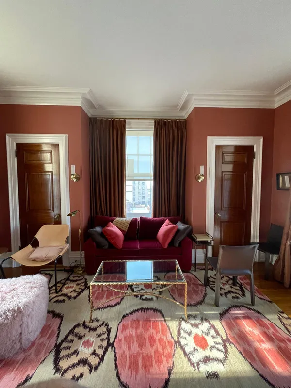 Living room with fresh terracotta paint and white trim by MMSL Contracting Corp