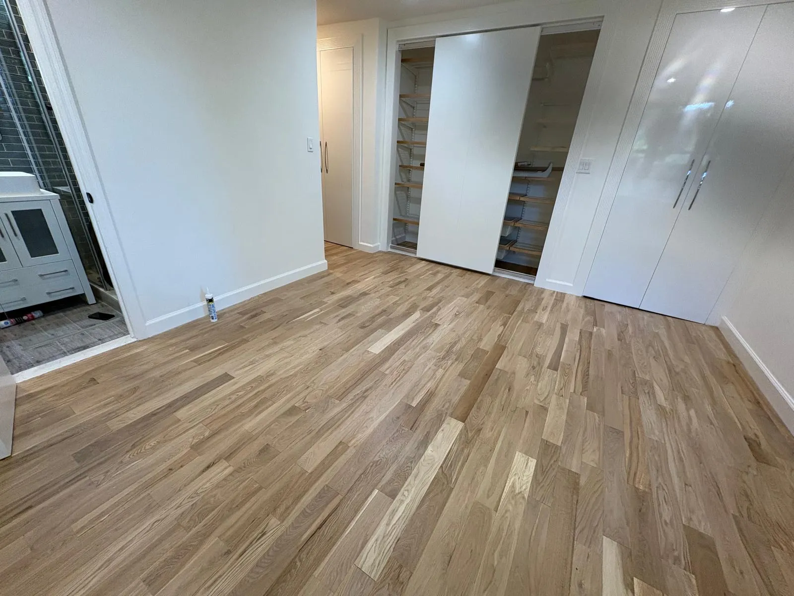 Custom sliding closet and storage system in a renovated Great Neck bedroom