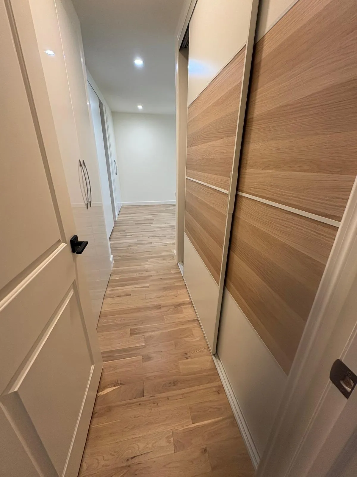 Open custom sliding closets along a renovated Great Neck hallway