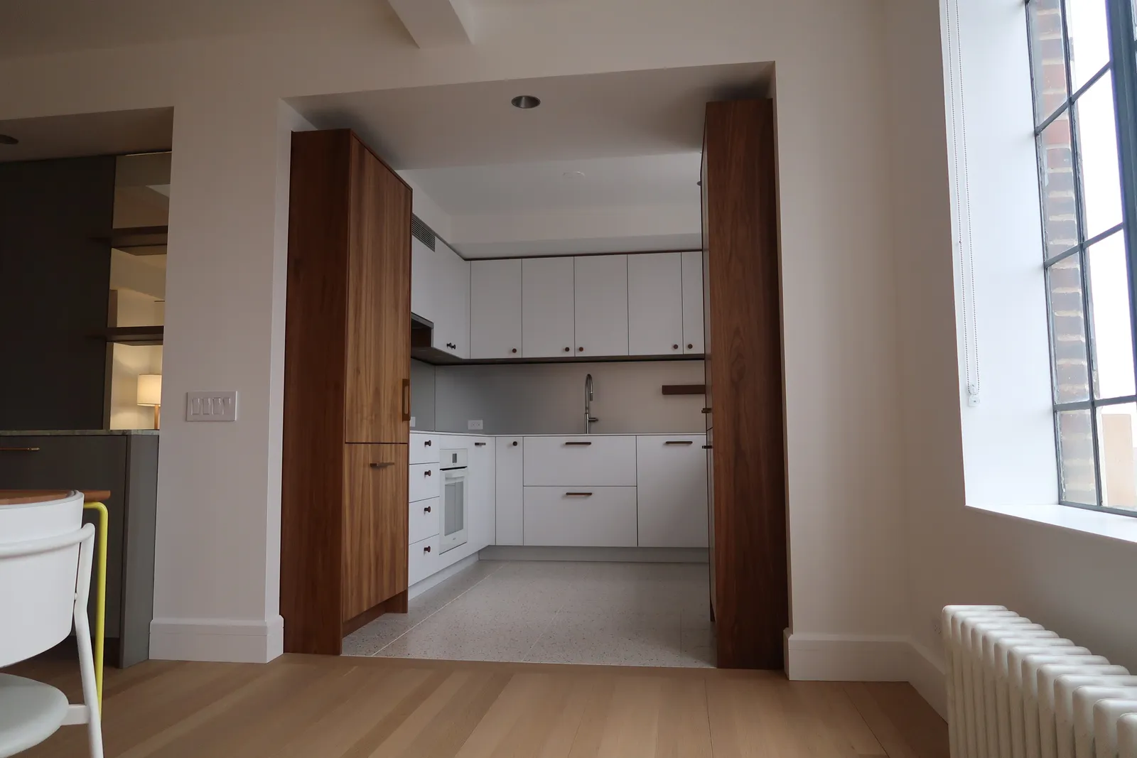 Custom white kitchen framed by walnut millwork at the Lafayette Residence