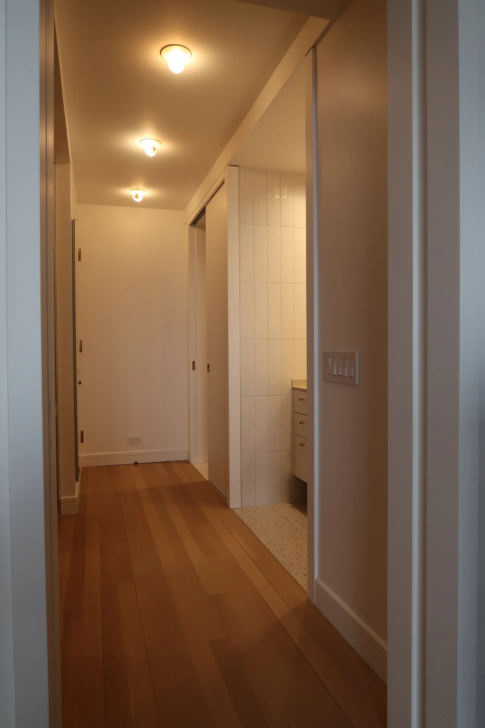 Entry hall with warm wood millwork and custom lighting at the Lafayette Residence