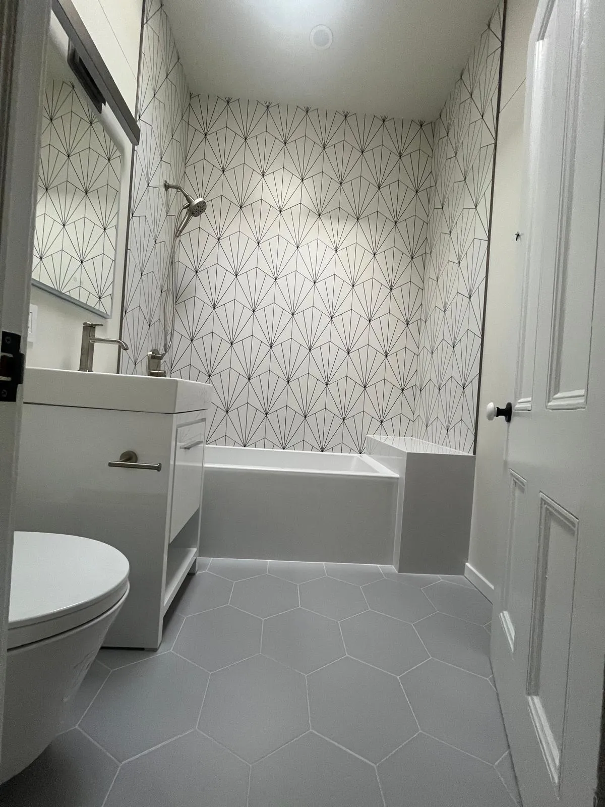 Bathtub and geometric wall tile in a bright Park Slope bathroom renovation