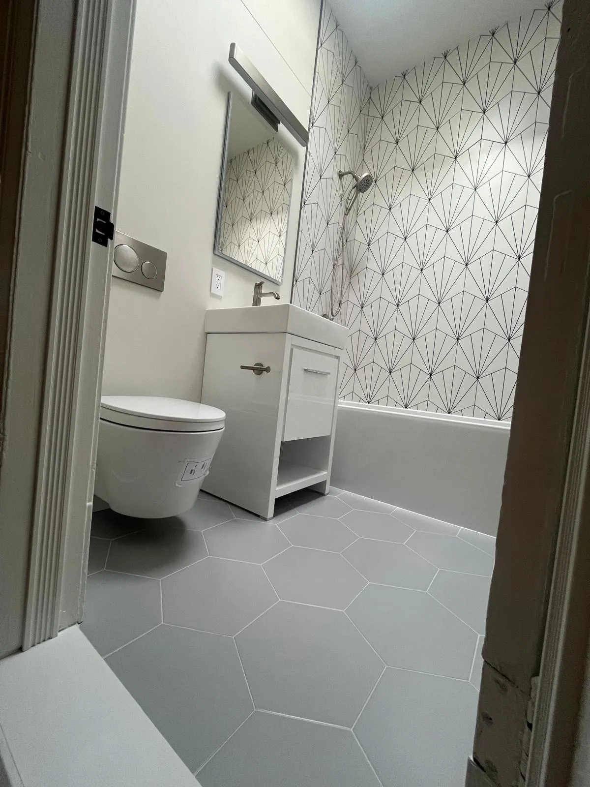Gray hex floor tile, white vanity, and bathtub in a renovated Park Slope bathroom