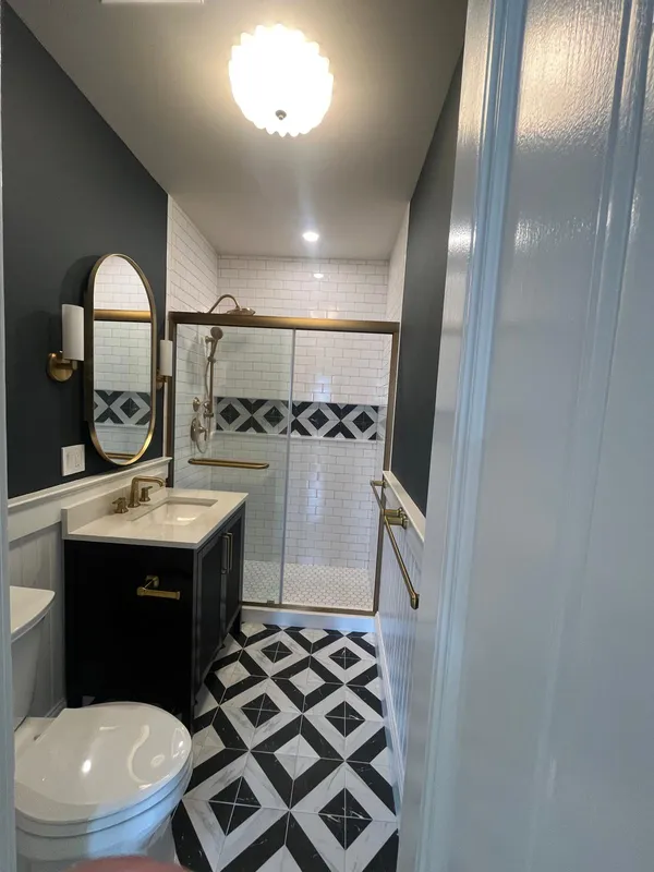 Renovated bathroom with subway tile and geometric floor by MMSL Contracting Corp
