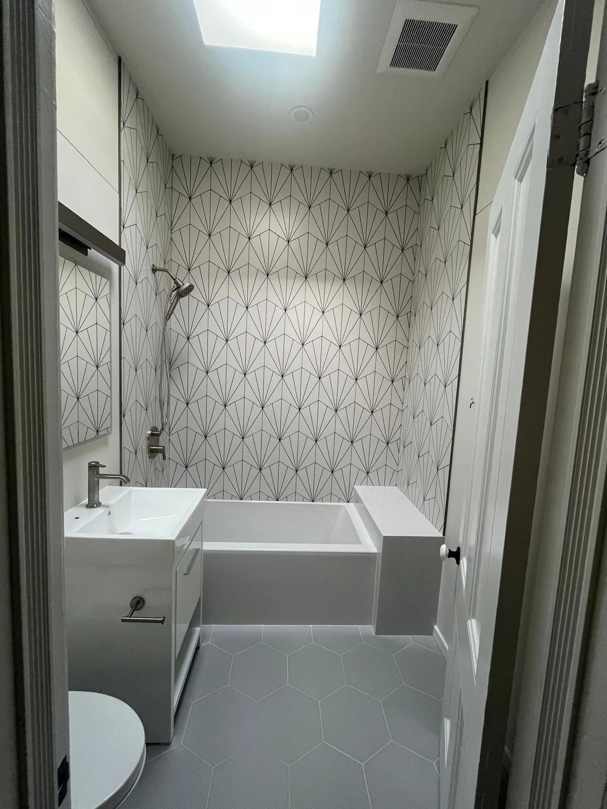 Park Slope bathroom with skylight, geometric wall tile, and gray hex floor tile